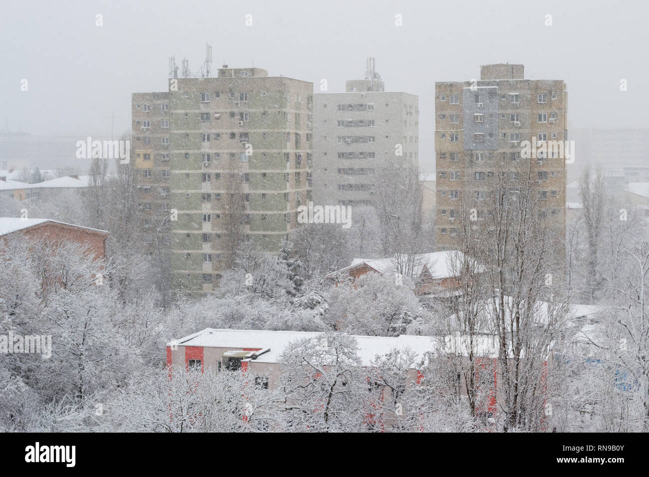 Puissante tempête de neige à Bucarest, Roumanie, avec de grands immeubles d'appartements à peine visible de la baisse rapide des flocons de neige. Les bâtiments urbains anciens duri Banque D'Images