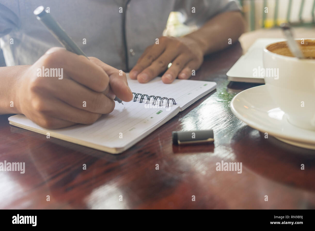 Jeune homme la rédaction de notes dans le coffee house Banque D'Images