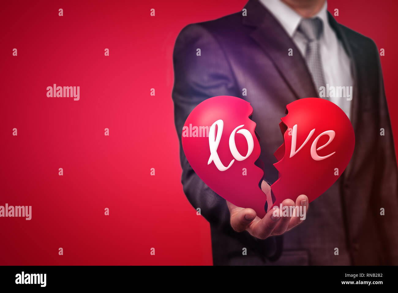 L Image D Un Homme In Suit Holding A Big Red Cœur Brise Avec Le Mot Amour Sur Fond Rouge Photo Stock Alamy