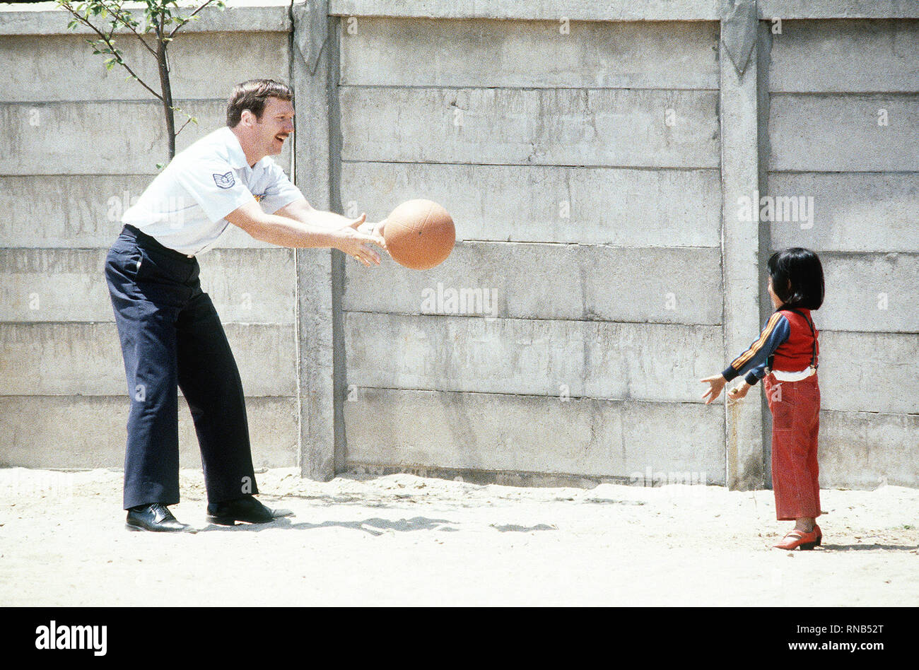 La Corée du Sud 1980 - Un sergent américain joue avec un enfant Amérasiens (l'enfant d'une femme coréenne et un militaire américain) au cours d'une visite à la maison pour les enfants amérasiens Vincents. Banque D'Images