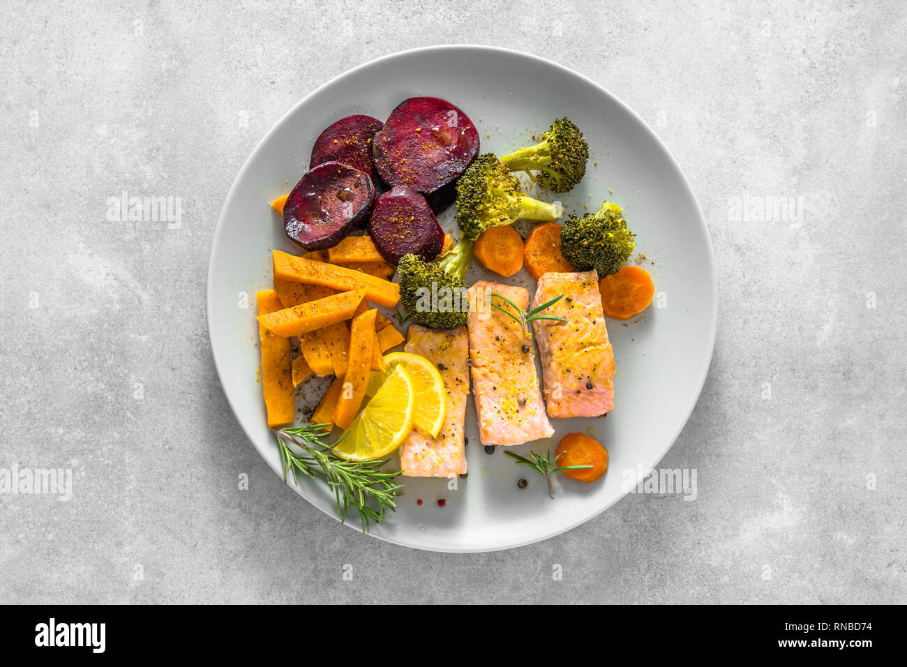 Dîner gastronomique avec du saumon cuit et légumes. L'alimentation saine sur assiette de légumes et un filet de poisson, vue du dessus. Banque D'Images