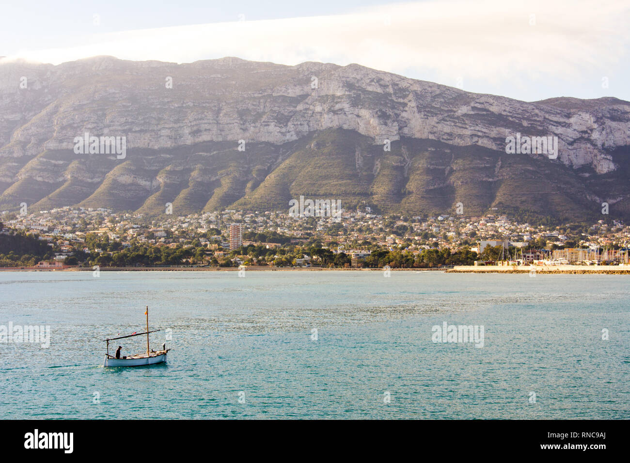 Un petit bateau de pêche entrant dans le port de Denia, Espagne. La montagne Montgó est dans l'arrière-plan Banque D'Images