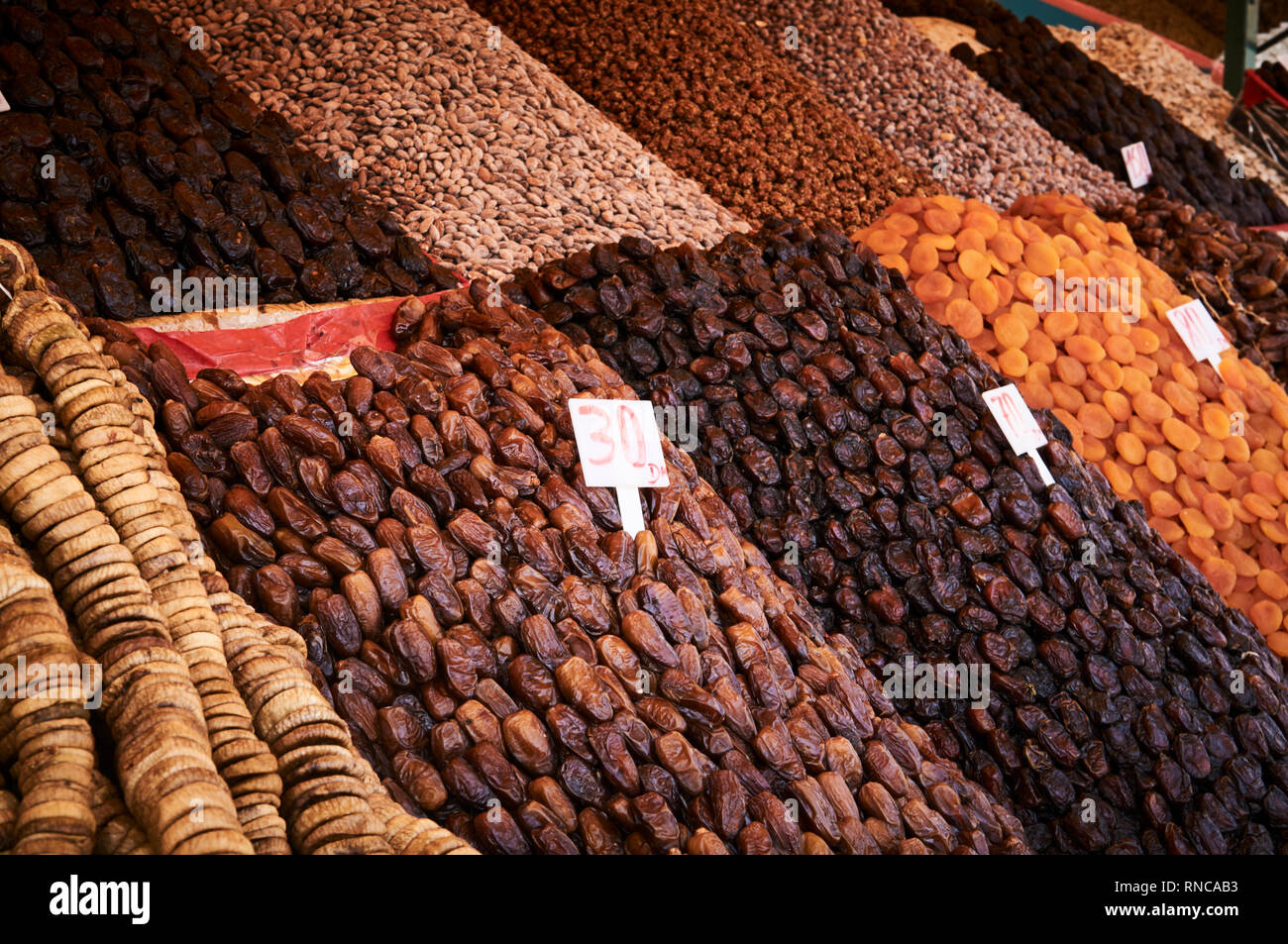 Des piles de fruits secs et d'oléagineux pour la vente dans un souk de la médina de Marrakech. Figues séchées, abricots, dattes, raisins secs, noix en vente dans une échoppe de marché. Banque D'Images