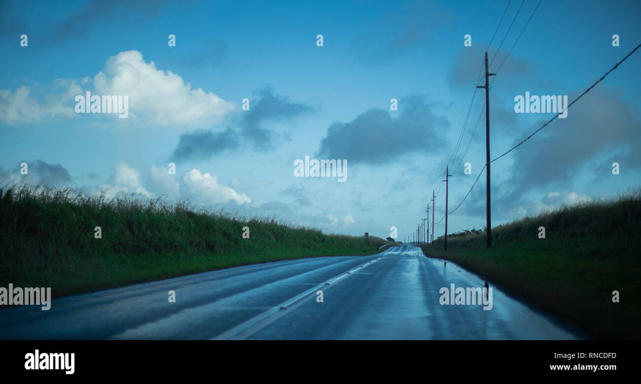 Route qui était un peu de taches d'eau sur elle, certains de taches d'eau reflètent la lumière avec un peu de nuages dans l'image Banque D'Images