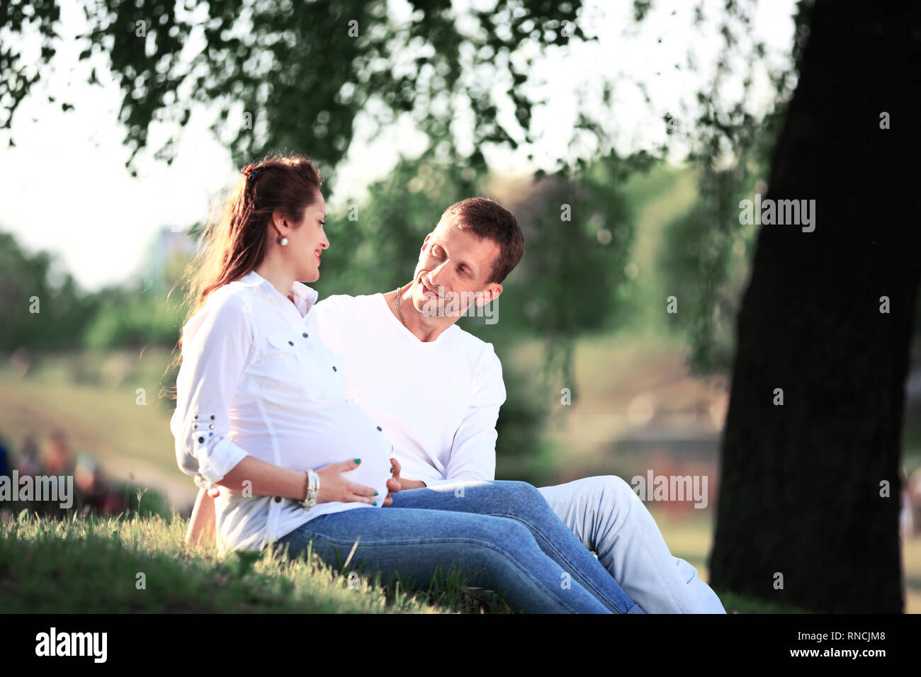 Femme enceinte avec son mari dans le parc. Riendly, joyeuse famille faire un pique-nique. Banque D'Images