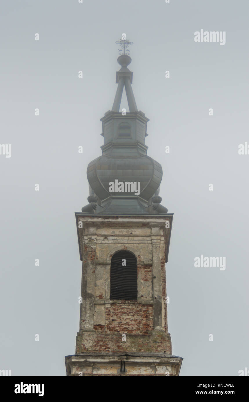 Un vieux clocher de l'église rustique dans le brouillard pendant la journée Banque D'Images