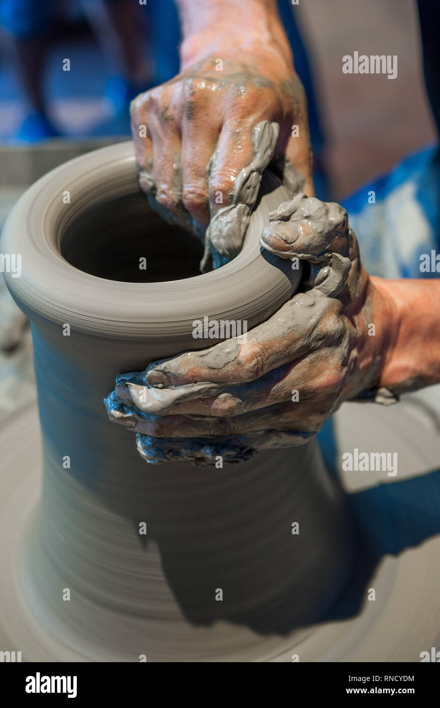 Potter au travail sur les poteries roue (close up hands et argile grise) Banque D'Images