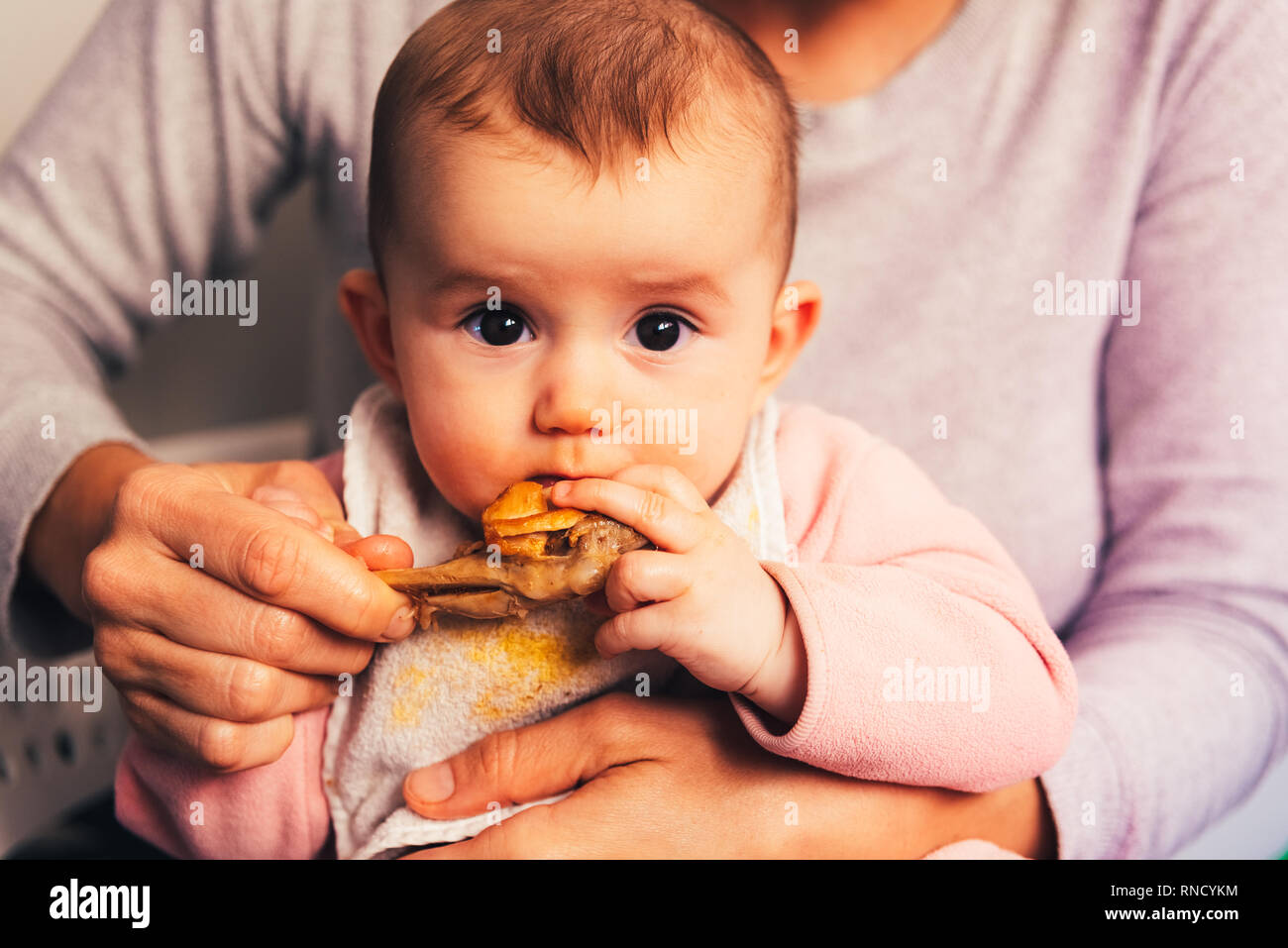 Bebe Age De 5 Mois De Manger Une Cuisse De Poulet A L Aide De L Enfant Conduit Le Sevrage Blw Methode Photo Stock Alamy