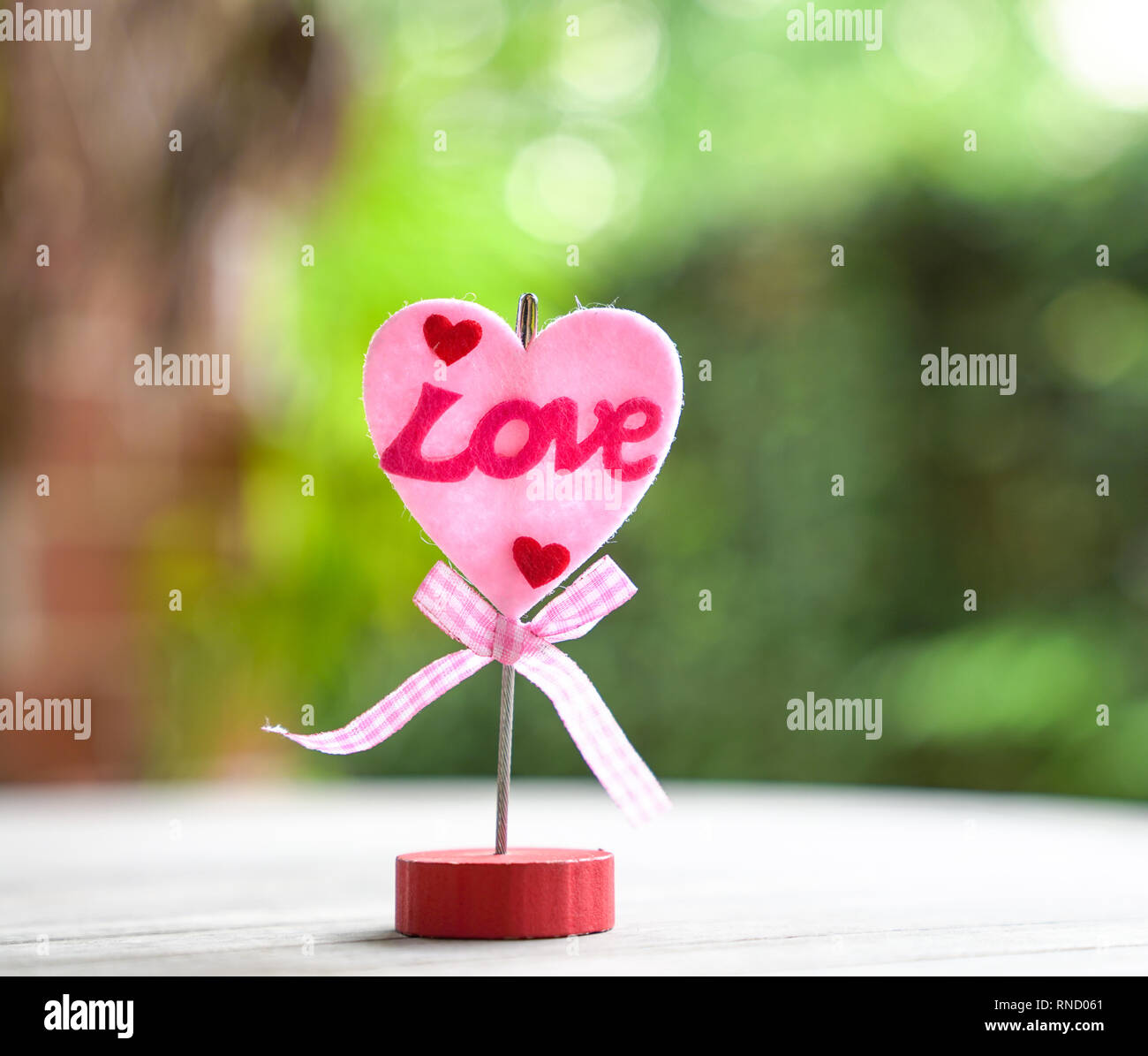 Love concept : forme de Cœur sur un support à mot amour et sur un jardin ou sur fond vert Banque D'Images