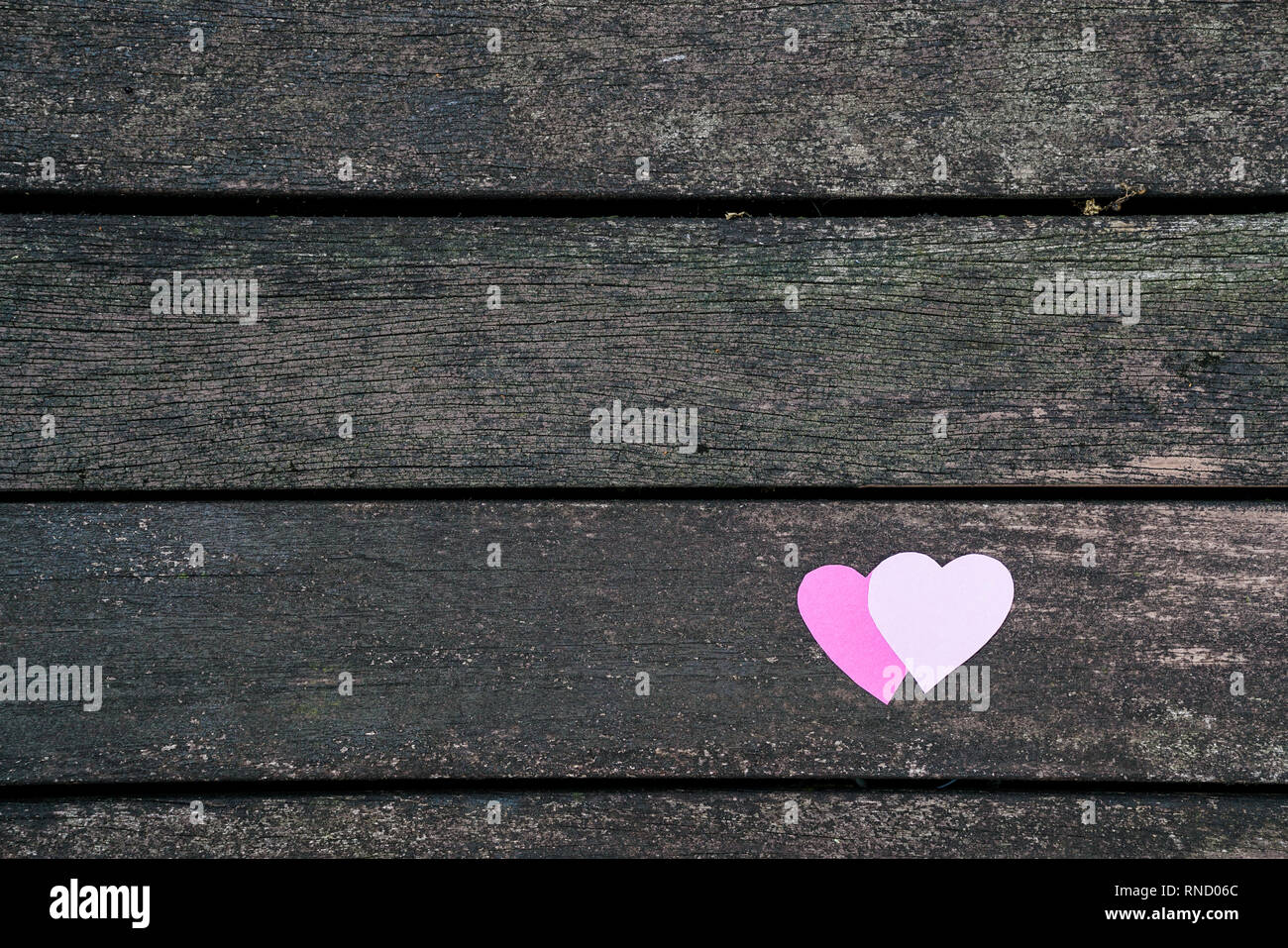Love concept : deux coeurs en papier sur une carte en bois sombre. Banque D'Images