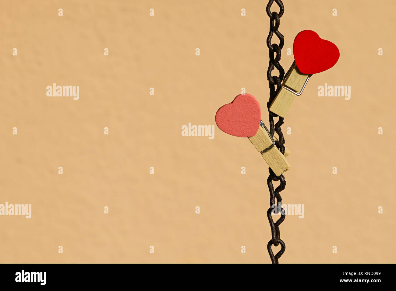 Love concept : deux clips rouge et rose avec forme de coeur sur une chaîne en acier Banque D'Images