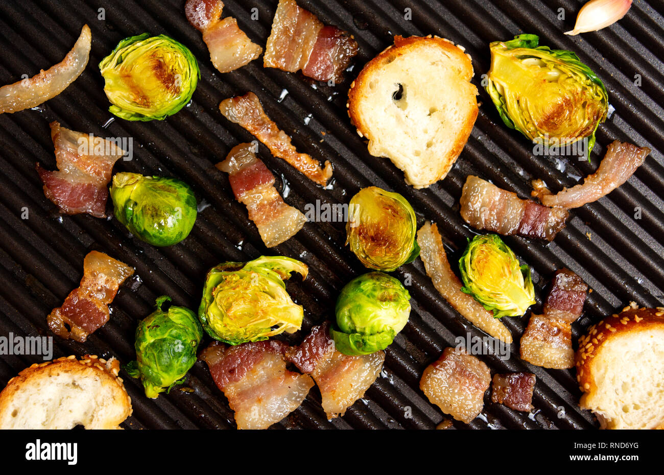 Tranches de pain avec du bacon sur un grill pour faire la bruschetta Banque D'Images Tranches de pain avec du bacon sur un grill pour faire la bruschetta Banque D'Images