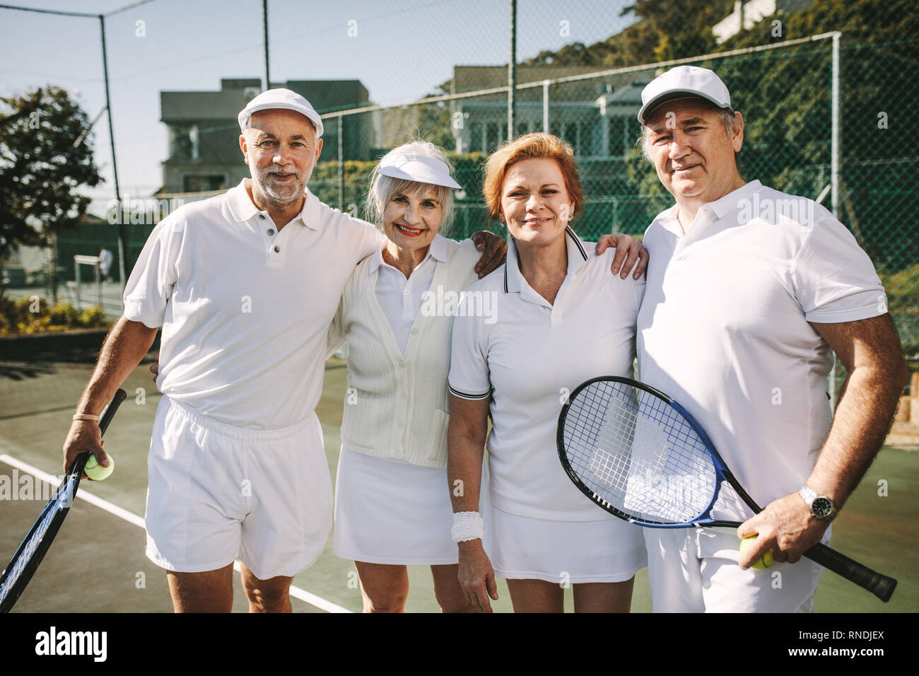Senior men holding tennis racket et ball femmes debout avec leurs partenaires. Les personnes âgées se tenant ensemble se tenant à jouer le double mixte hafid Banque D'Images