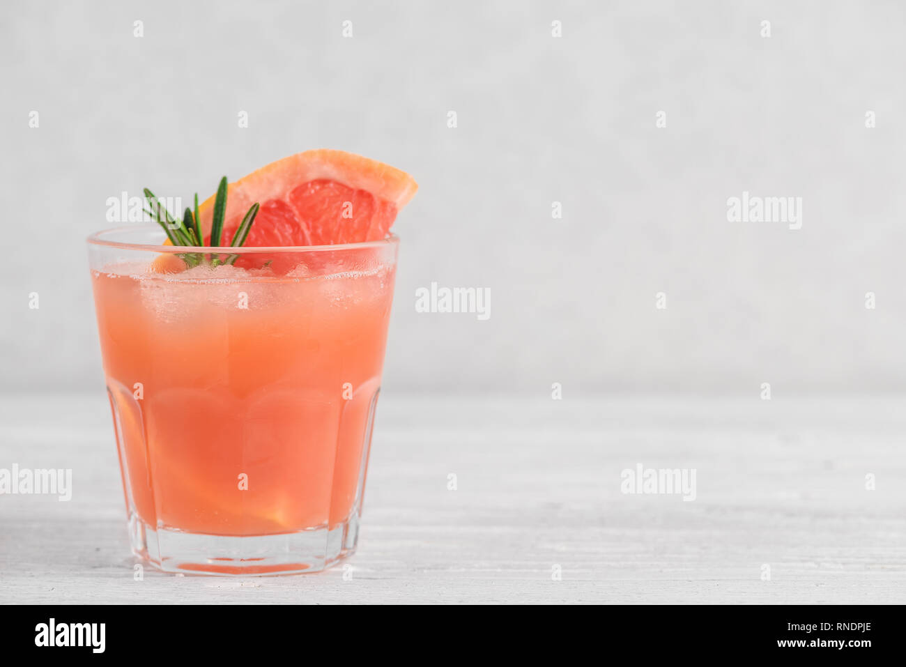 Cocktail pamplemousse rafraîchissement au romarin et glace sur fond blanc. Agrumes saine boisson d'été. close up Banque D'Images