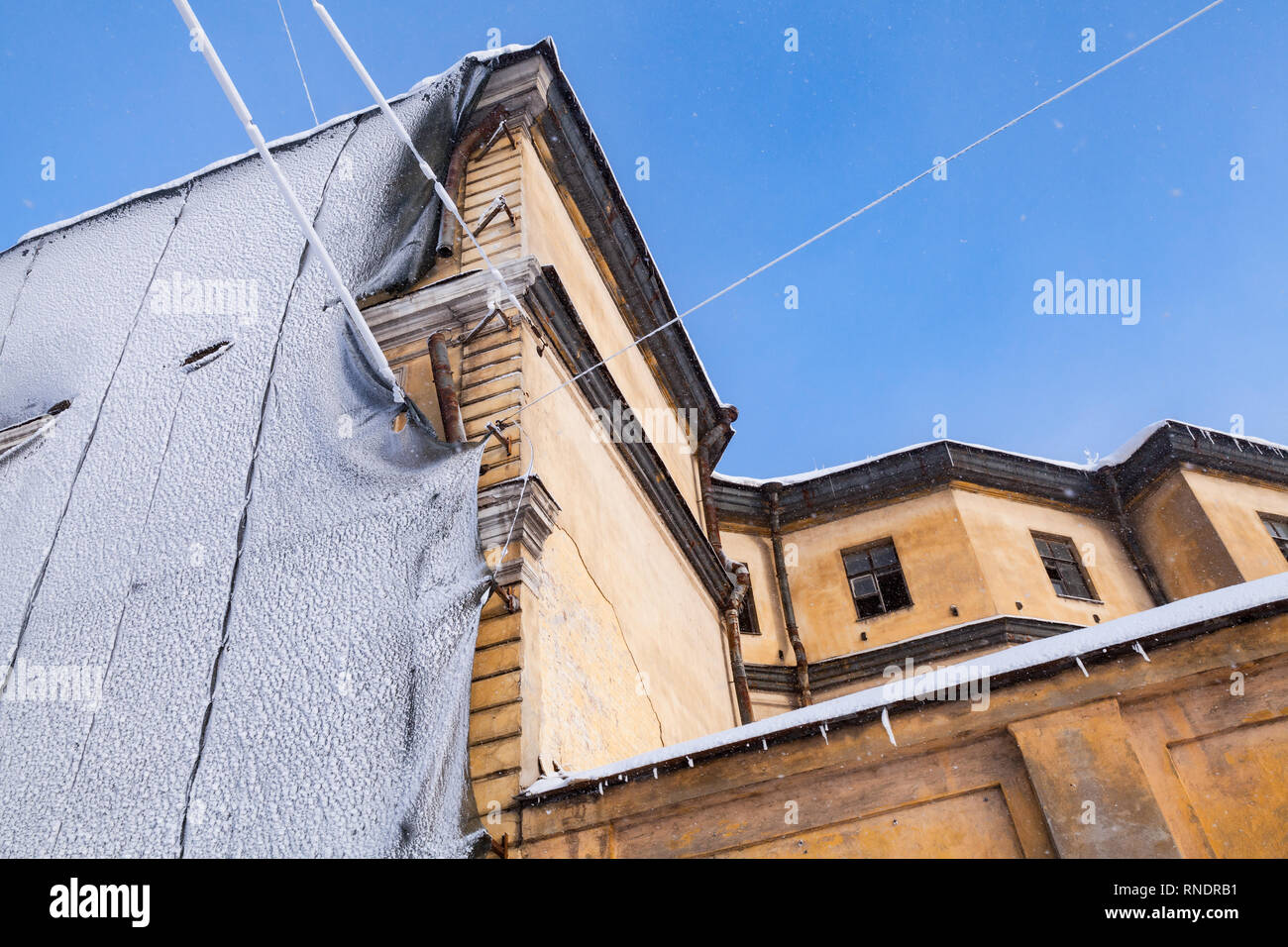 La façade de l'immeuble jaune ancienne en cours de rénovation à journée d'hiver. Saint Petersburg, Russie Banque D'Images