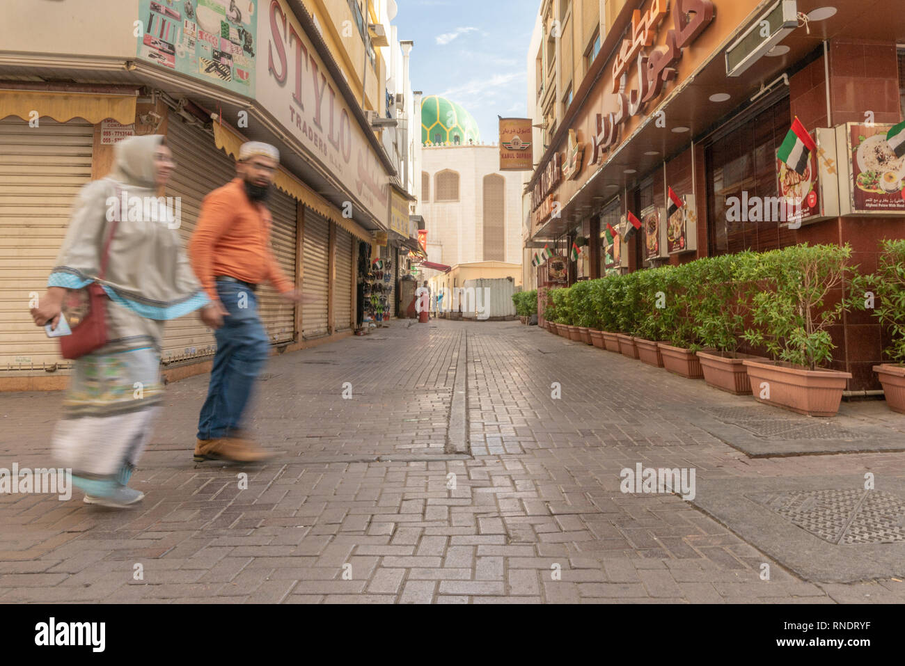 Un couple en train de marcher dans une rue de la populaire et ethnique quartier de Deira à Dubaï, Émirats arabes unis,, Banque D'Images