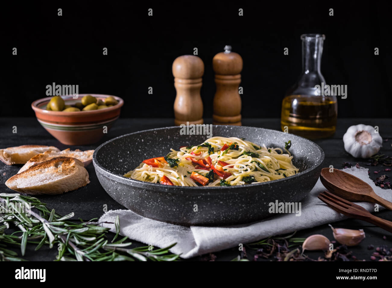 Casserole de pâtes italiennes cuites. Spaghetti traditionnel repas avec légumes et olives noires sur fond rustique Banque D'Images