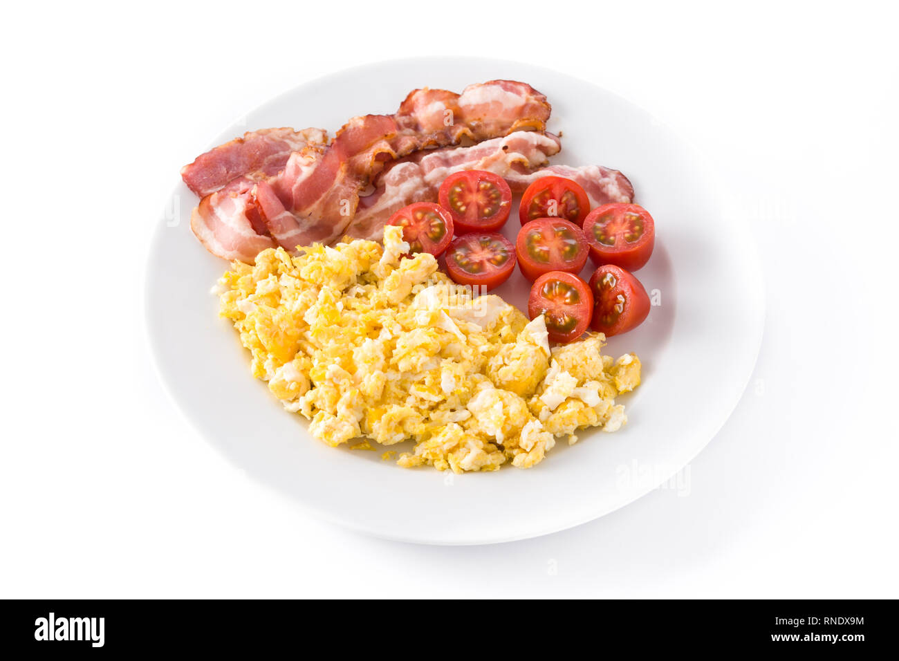 Petit-déjeuner avec des œufs brouillés, bacon et tomates isolé sur fond blanc Banque D'Images