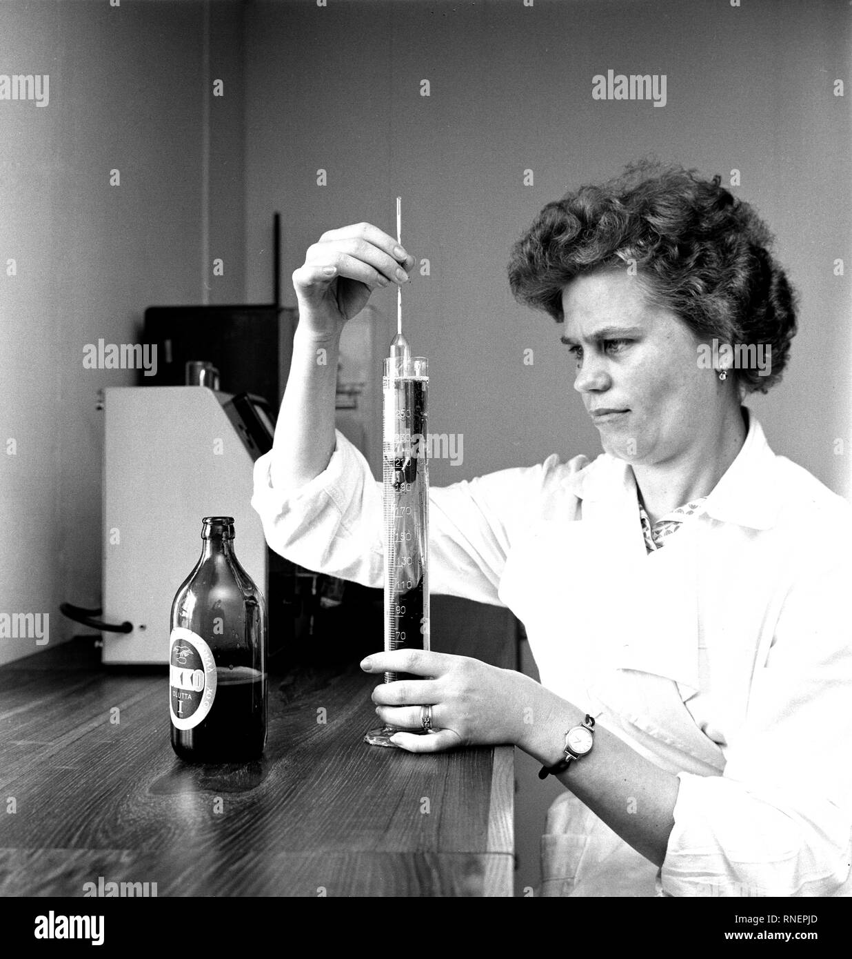 L'histoire de la Finlande Kotka - Brasserie à vapeur inspecteur inspecte la qualité de la bière en bouteille. ca. 1960 Banque D'Images