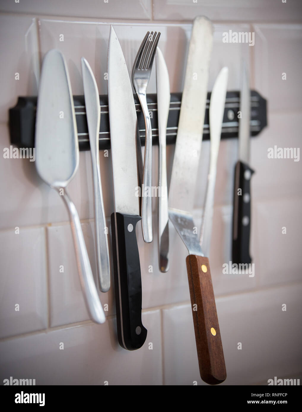 Coutellerie de cuisine accroché sur la bande magnétique sur le mur. Couteaux, fourchettes Banque D'Images