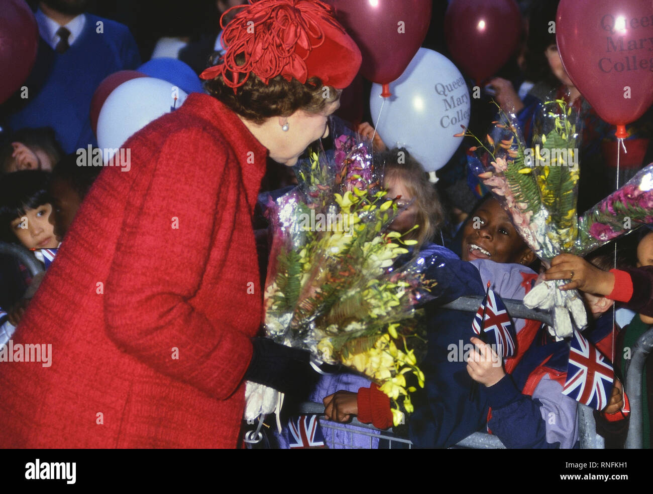 Sa Majesté la Reine Elizabeth II sur une visite royale au Queen Mary College entouré d'enfants heureux et excité. Londres. L'Angleterre. UK. Circa 1980 'SI Banque D'Images