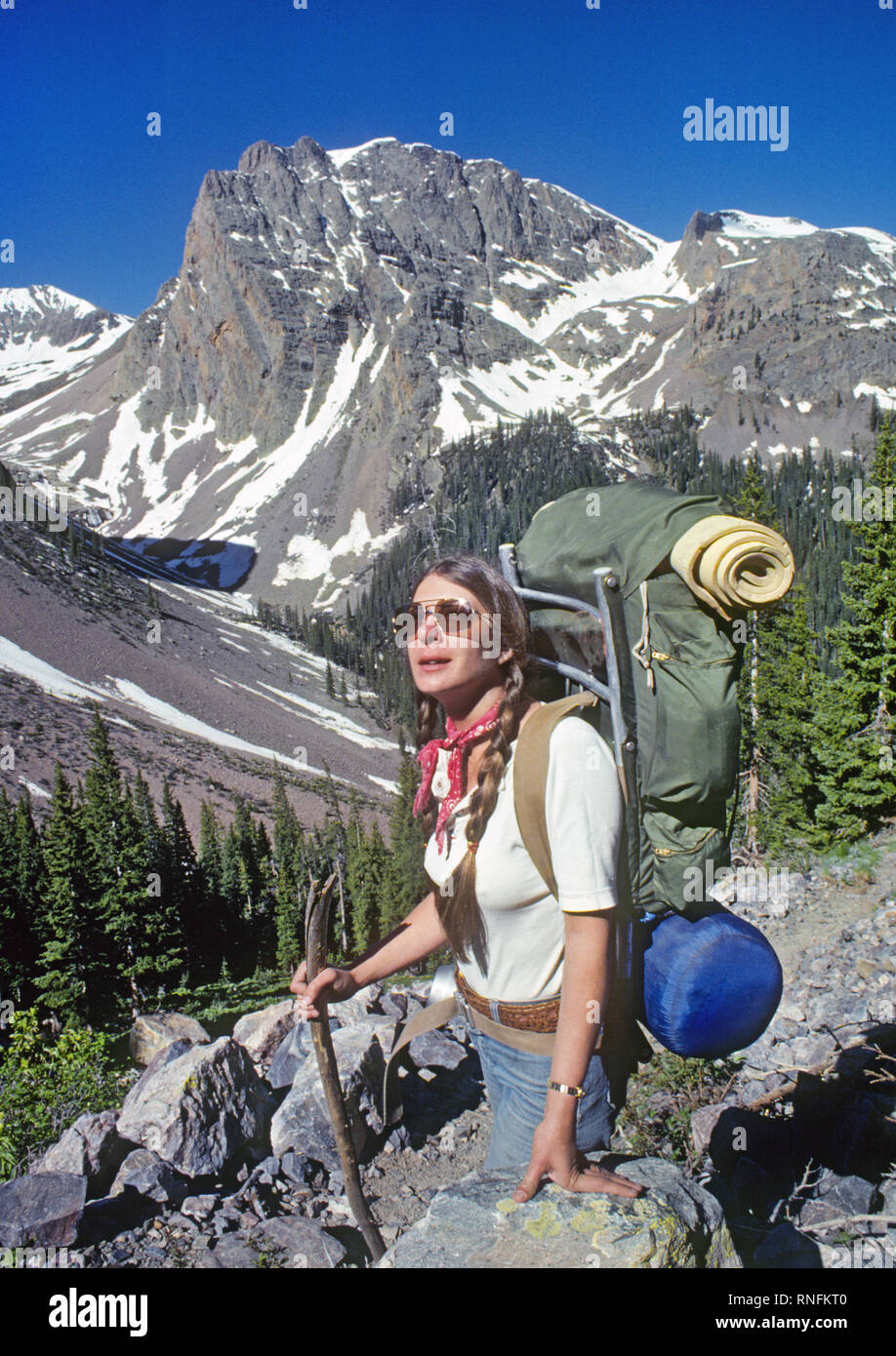 Une femelle backpacker repose sur un éboulis qu'elle négocie une section alpin et robuste de la ligne de partage dans le sentier de l'avancement National de San Juan Banque D'Images