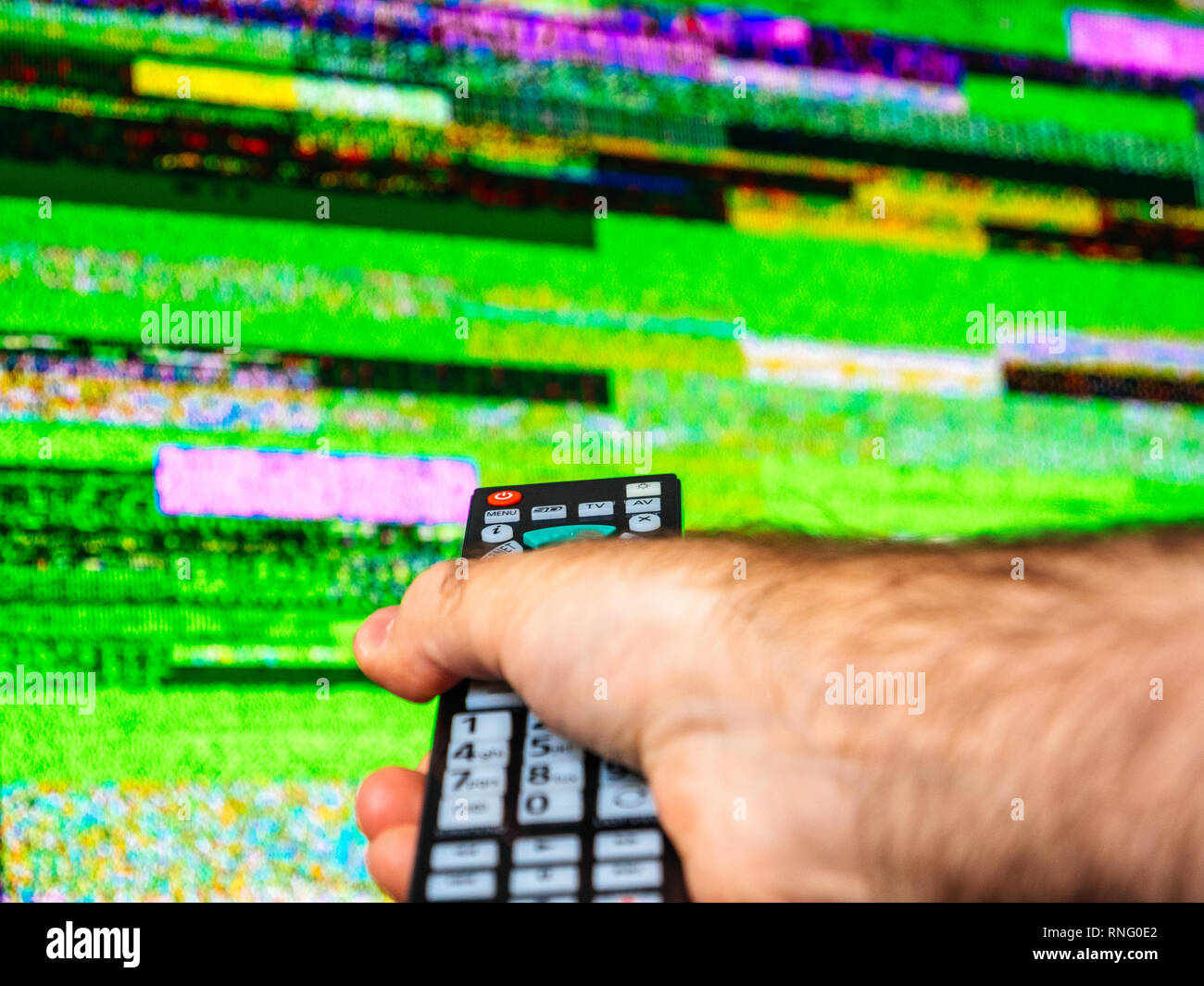 La main des hommes mauvais d'appuyer sur les boutons afin de résoudre le problème avec le signal du bruit statique provenant d'une télévision à écran plat de télévision numérique numérique Banque D'Images