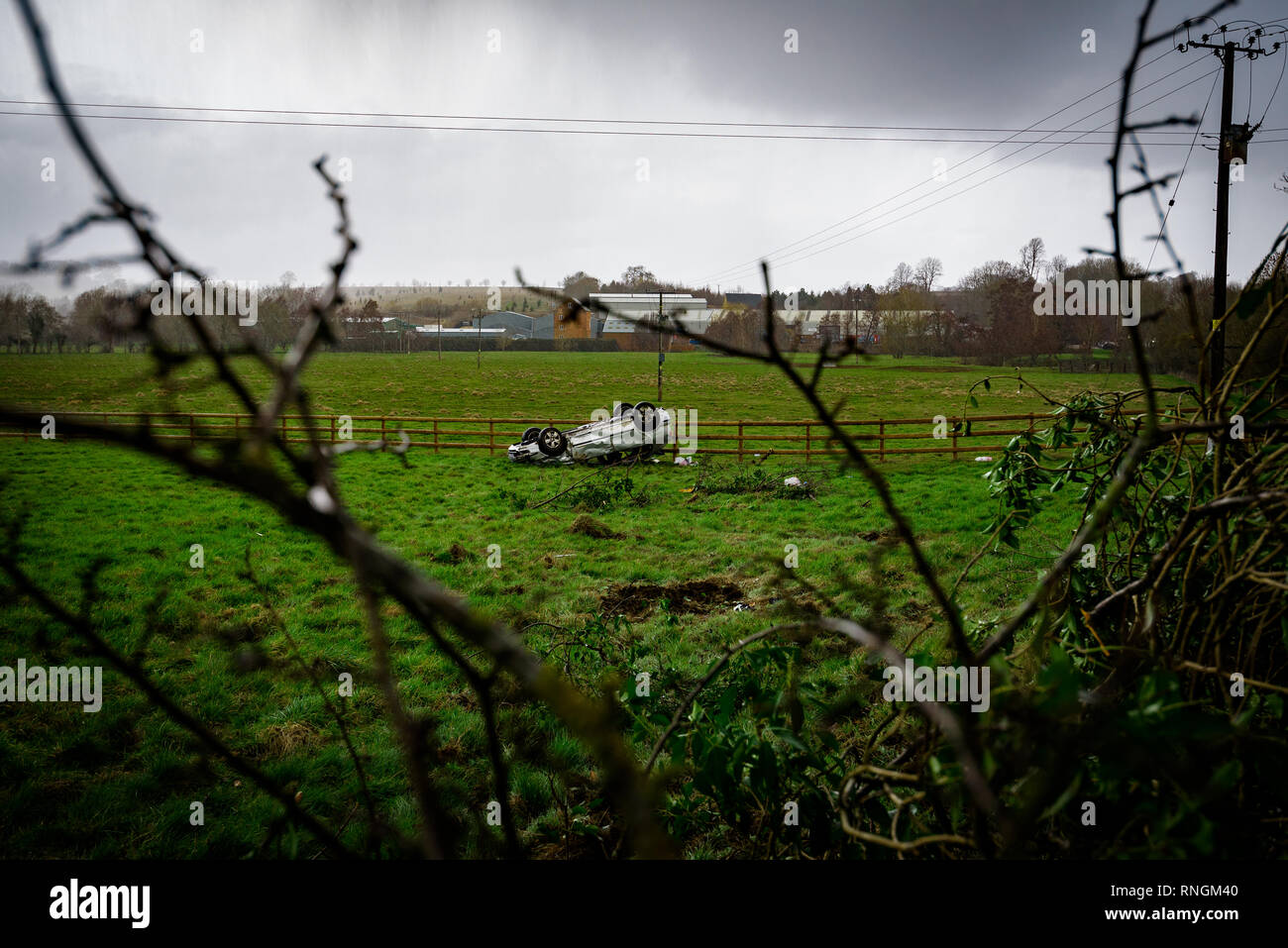 Accident de voiture et location de véhicule ; dommages à l'envers dans un champ après une collision à haute vitesse. Banque D'Images