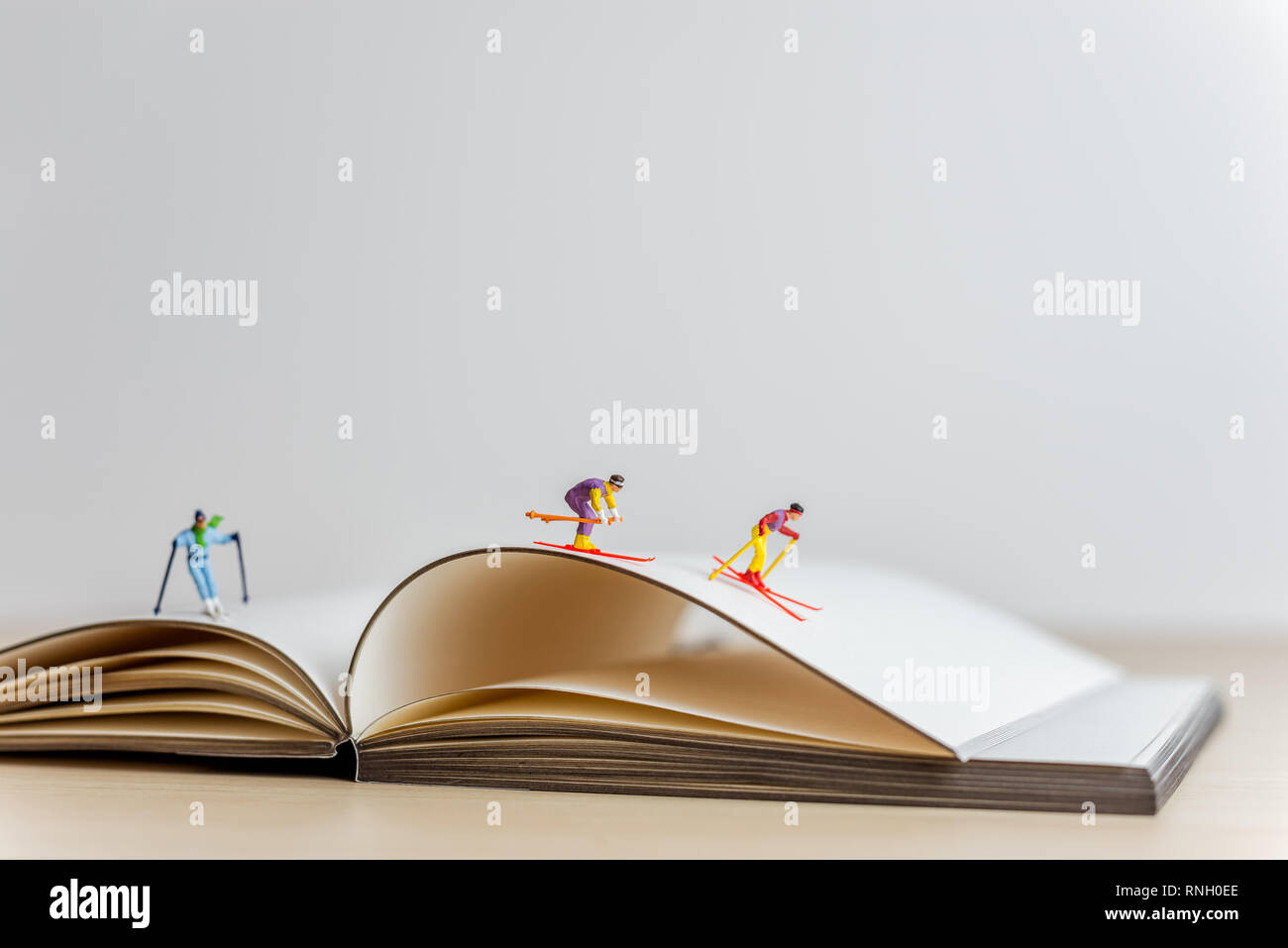 Les skieurs en glissant sur la miniature livre ouvert. Sport et voyage concept. Banque D'Images