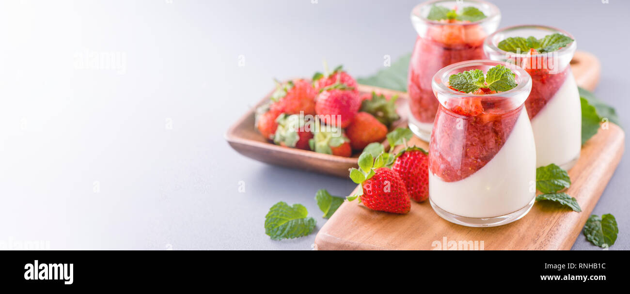Delicous et nutritifs couleur double (couleur) desserts fraises à la menthe et les dés de sarcocarp topping isolé avec fond bleu aérée, copy space Banque D'Images