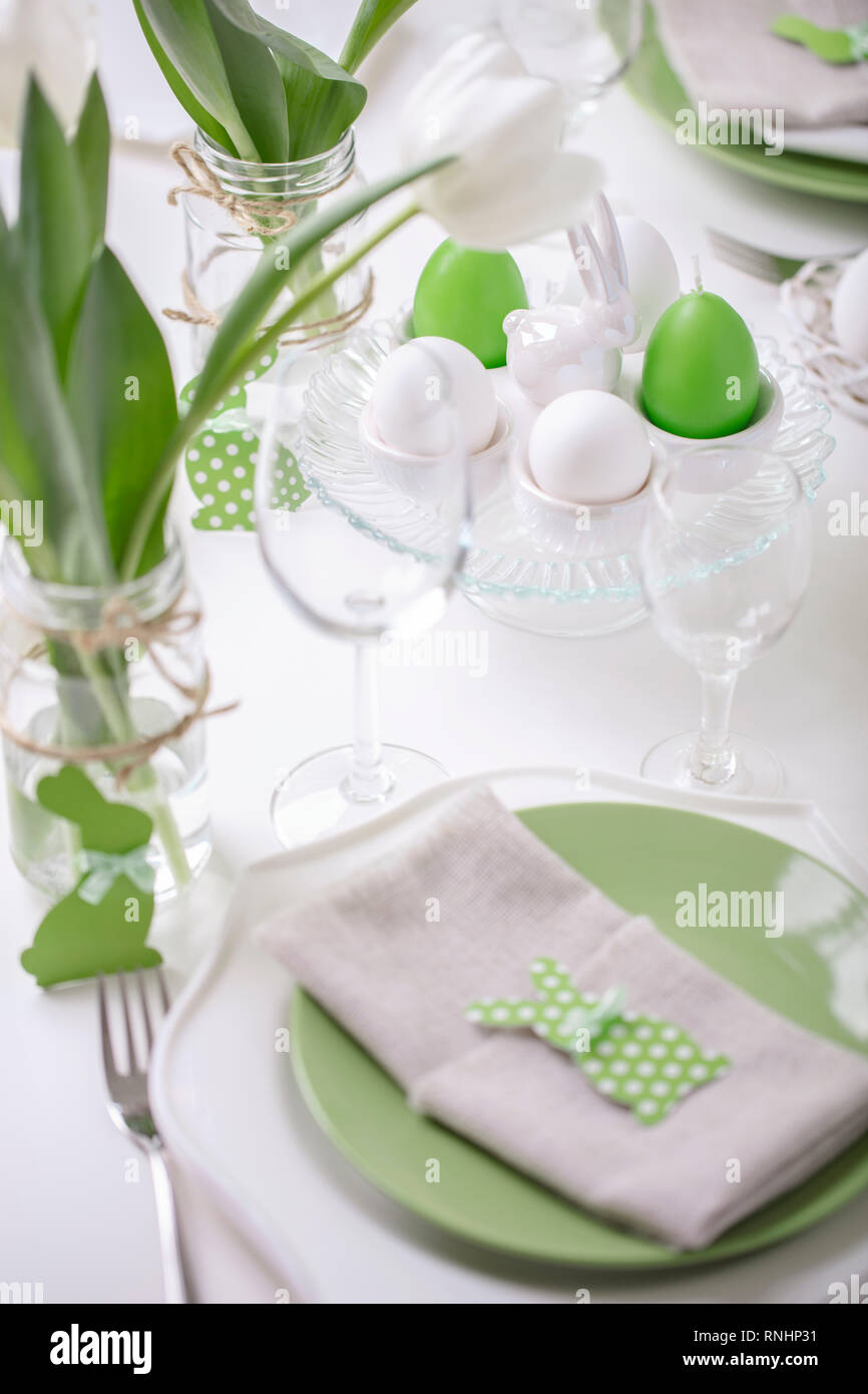 Et décor de table de la table de Pâques est un vase avec des tulipes blanches et plats de couleur vert et blanc. Décoration de pâques avec pois blancs. Selec Banque D'Images