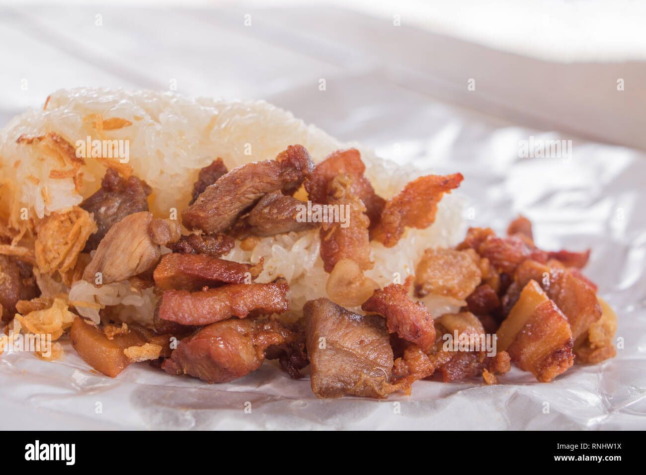 Poêlée de porc Close up avec riz gluant sur enrouler du papier restauration rapide en Thaïlande Banque D'Images
