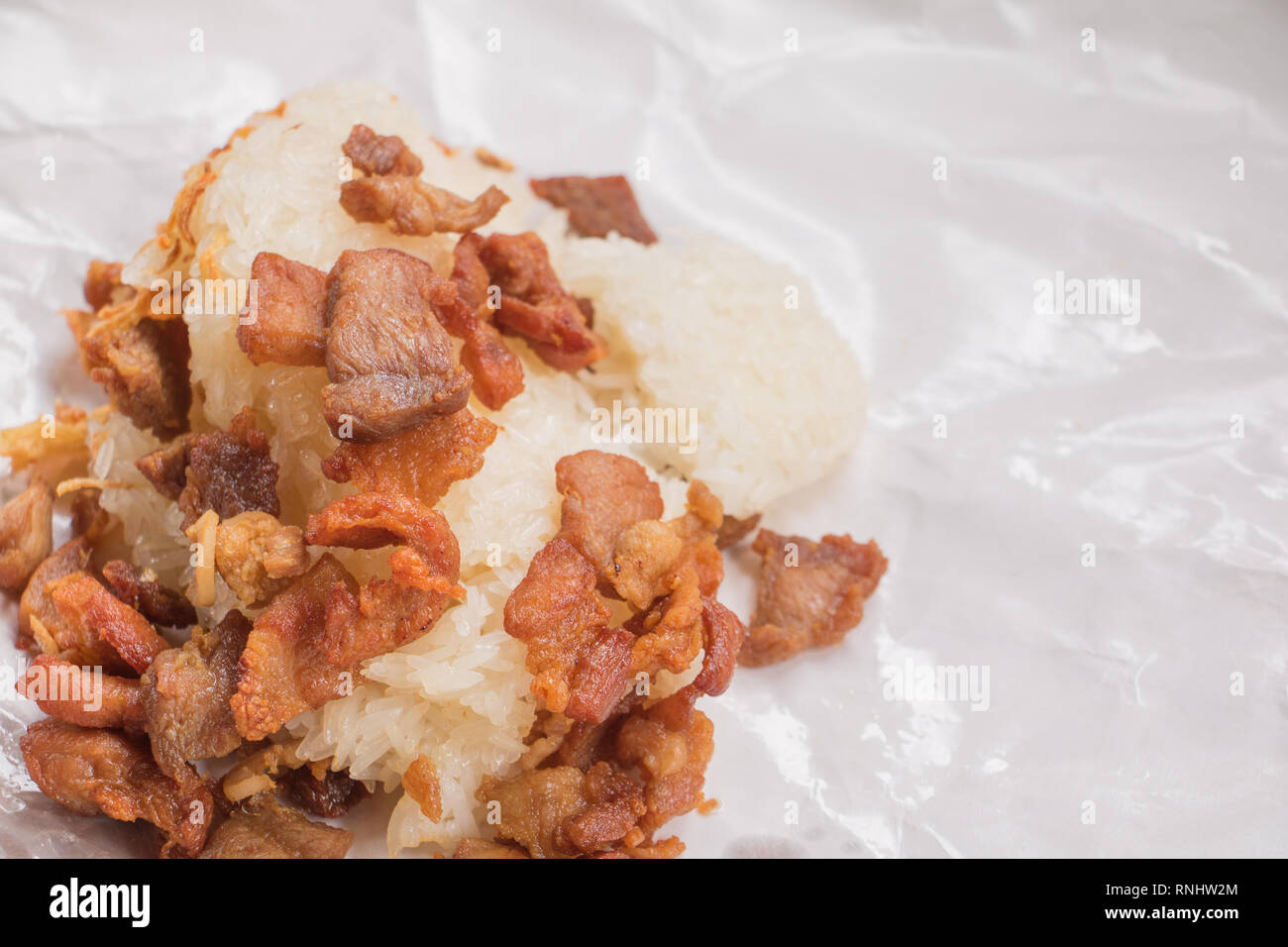 Poêlée de porc Close up avec riz gluant sur enrouler du papier restauration rapide en Thaïlande Banque D'Images