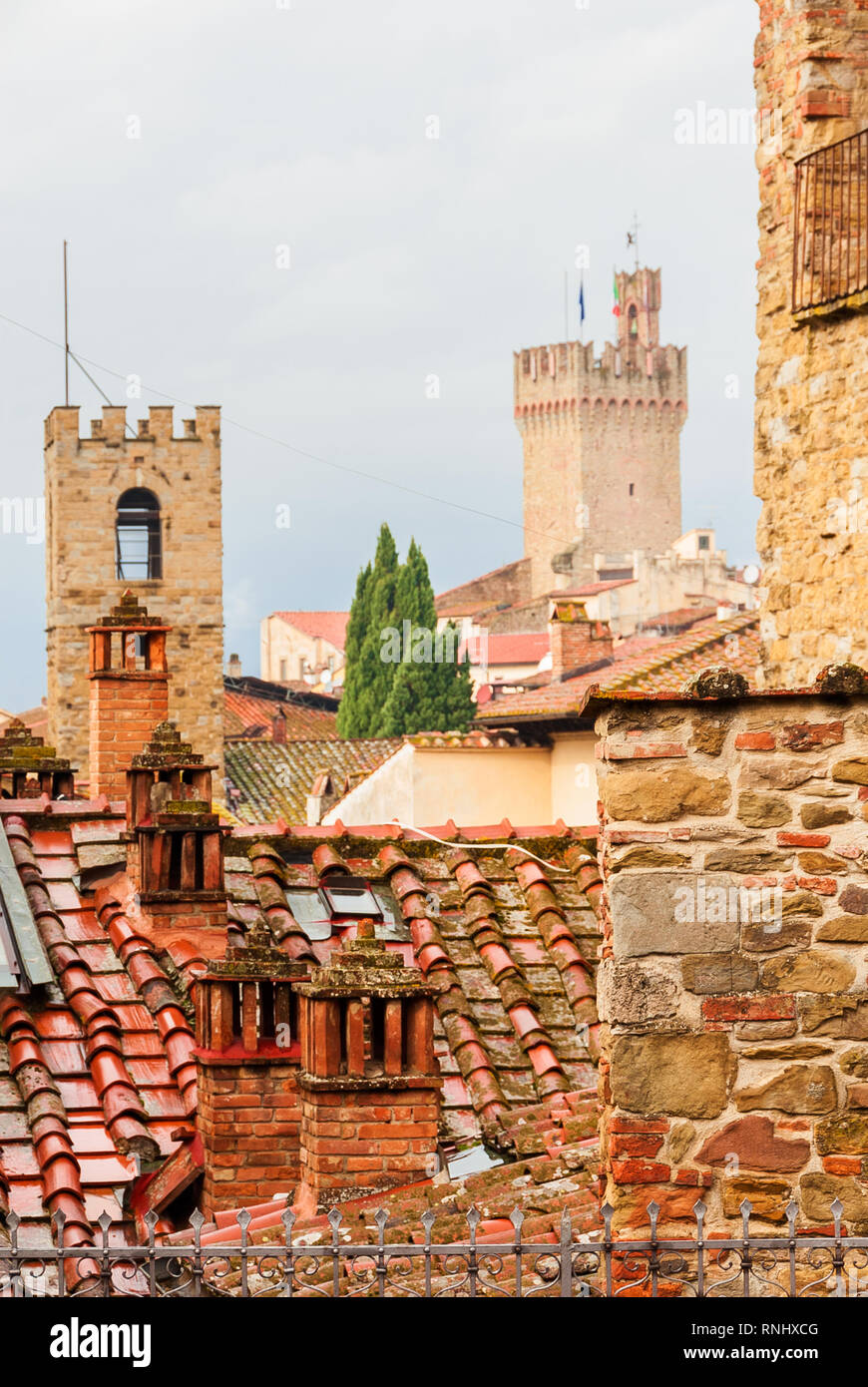 Voir d'Arezzo centre historique médiéval de toits caractéristique des tuiles, et cheminée avec du vieux tours à l'arrière-plan Banque D'Images
