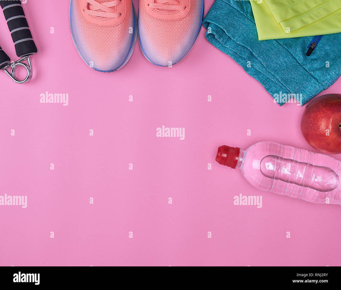 Chaussures de sport et autres articles textiles pour la remise en forme sur un fond rose, vue du dessus Banque D'Images