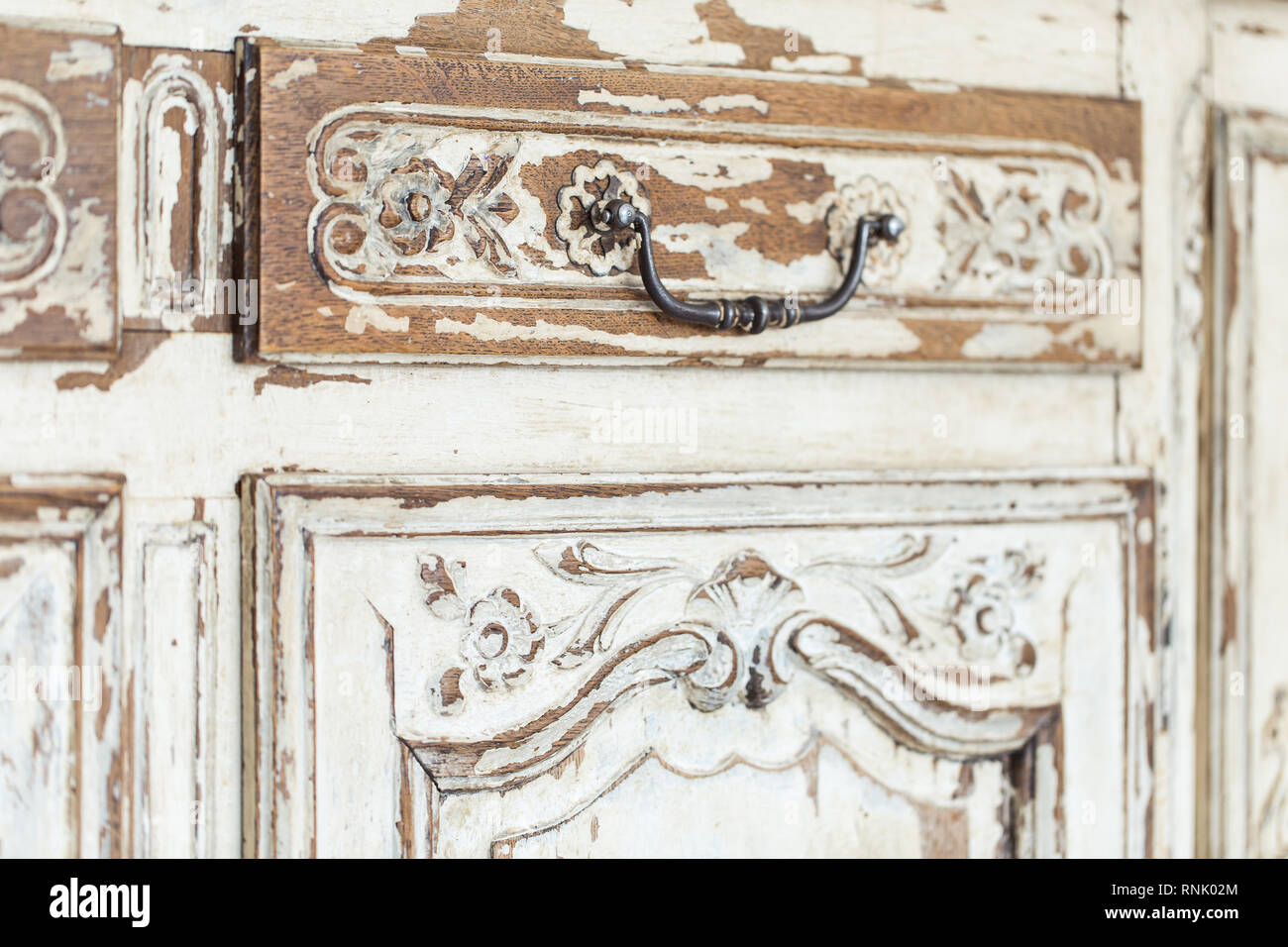 Vintage commode avec couleur blanc sculpture avec la décoloration et poignée en métal. Close-up. Selective focus Banque D'Images