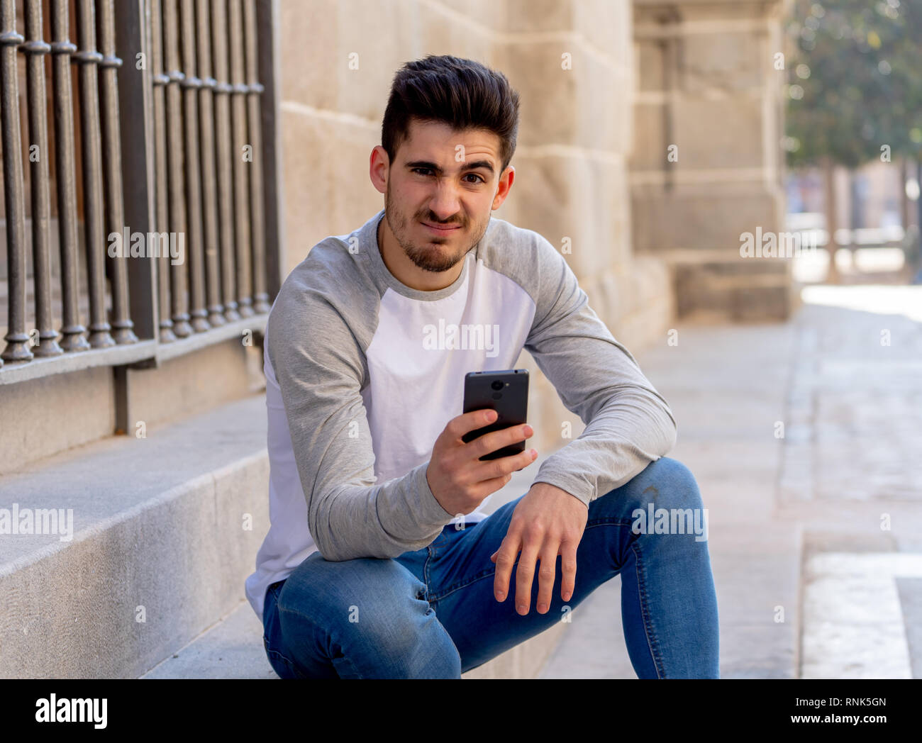 Portrait de jeune homme étudiant réagir négatif à poster dans les médias sociaux ou réseau dating app avec dislike showing thumb vers le bas. En réseau social RWTUV, prendra part Banque D'Images