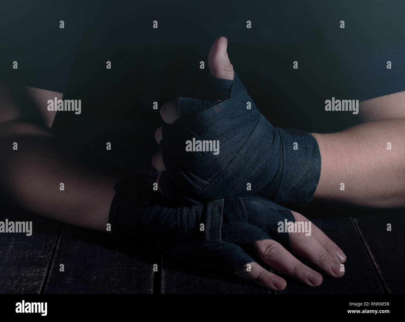 Mains de fighter dans un style moderne sur fond noir. Concept de soins de santé. Corps musculaire remise en forme. Mode de vie sain. Fond sombre. Banque D'Images