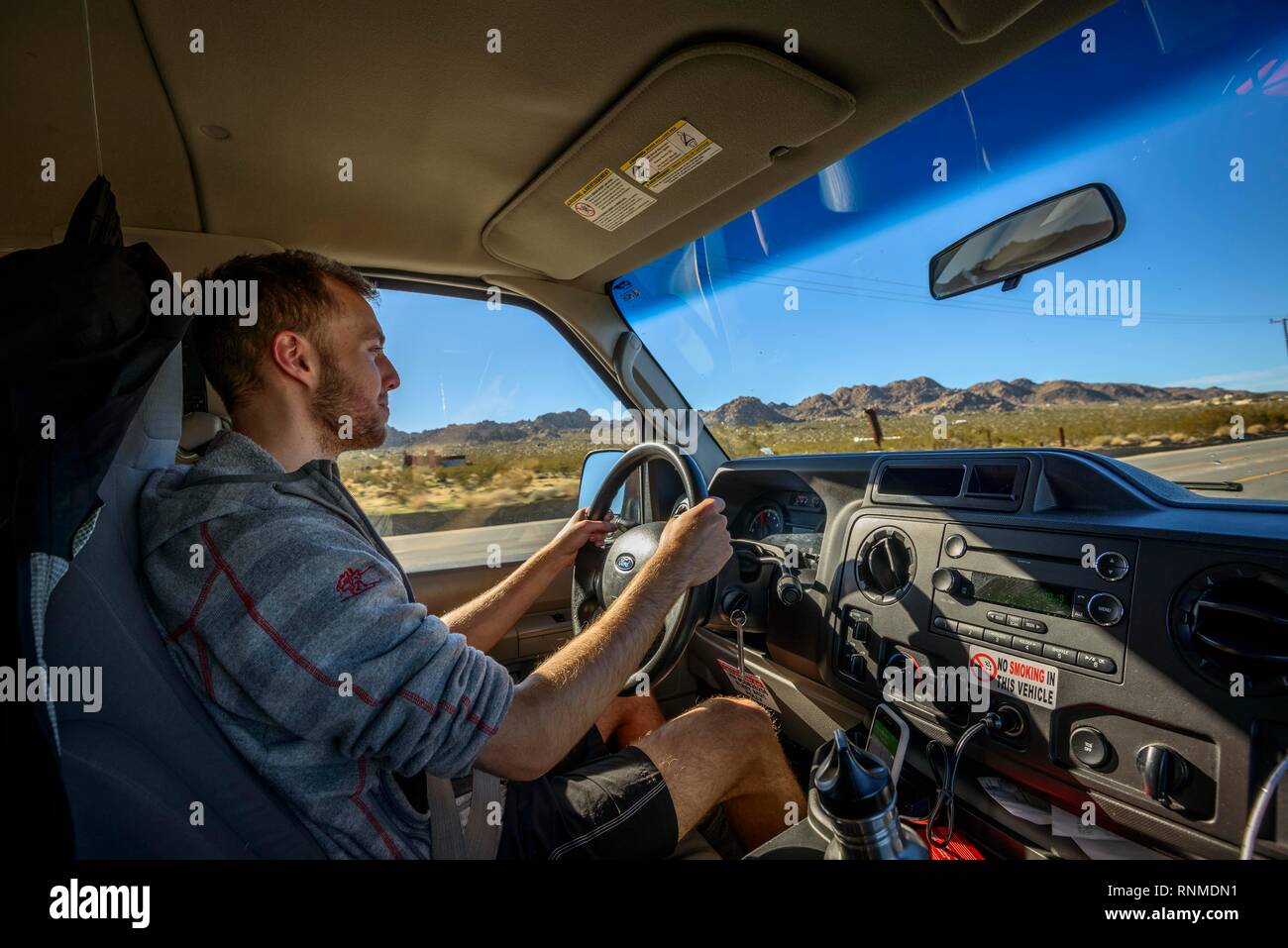 Jeune homme au volant d'une voiture dans un camping-car, en Californie, USA Banque D'Images