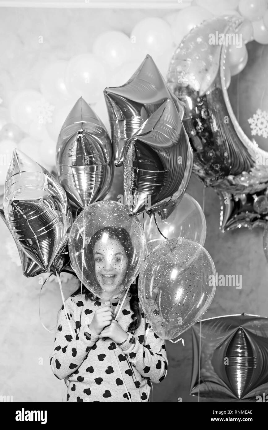 Enfant heureux sourire avec golden silver star ballons, noël. Petite fille fêter le nouvel an et les vacances de Noël. Célébration de fin d'année. Décor parti Banque D'Images