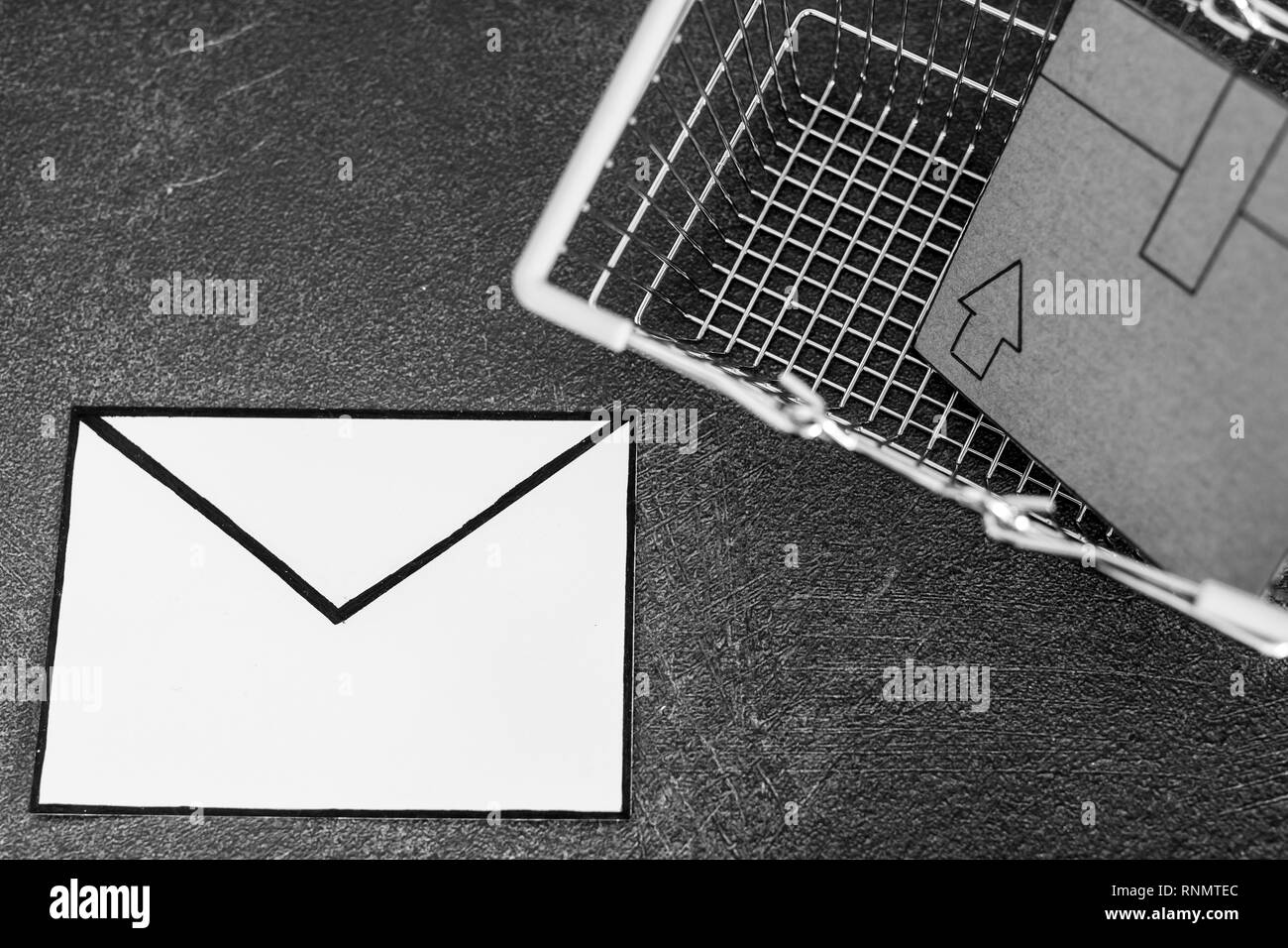 Panier avec des colis en carton et enveloppe e-mail sur le béton 24, concept de l'expédition et le suivi de vos livraisons en ligne Banque D'Images
