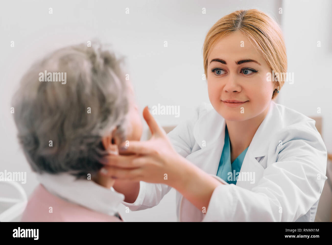 L'examen oto-rhino-laryngologiste glandes du patient au cabinet médical Banque D'Images