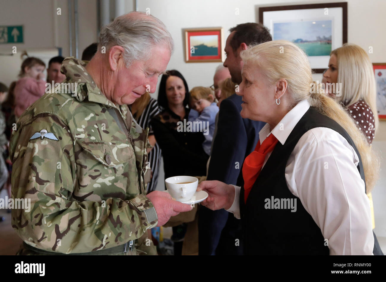 Le Prince de Galles, le Colonel, Welsh Guards est servi un verre par Maggie Cooper qu'il rencontre des membres de la famille et du 1er Bataillon Welsh Guards après leur retour d'Afghanistan, à Elizabeth Barracks, Pirbright Camp à Woking. Banque D'Images