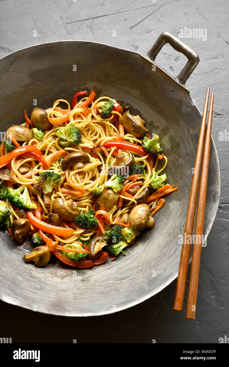 Nouilles Udon sautés avec légumes en wok casserole sur fond noir en noir. Des  légumes sautées avec spaghetti dans un style asiatique Photo Stock - Alamy