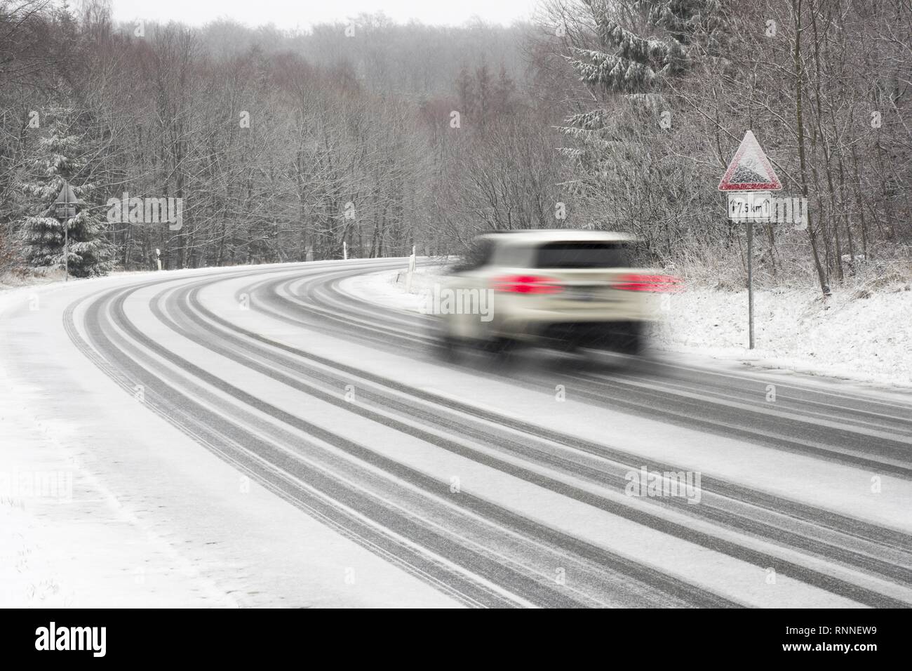 Voiture roulant sur route couverte de neige, Avertissement, gradient, Hesse, Allemagne Banque D'Images