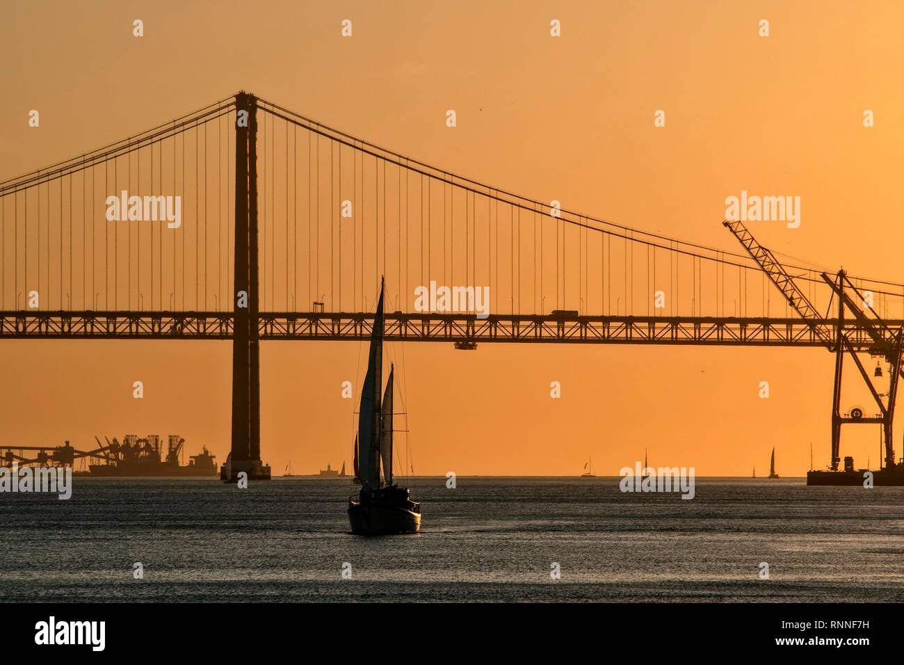 Soirée ambiance au Rio Tejo avec voilier et le pont Ponte 25 de Abril, Lisbonne, Portugal Banque D'Images