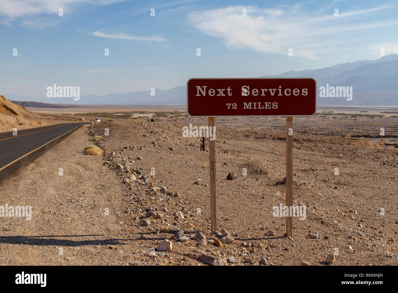 Une 'nouvelle' Services 72 miles signe au début de la route menant de Furnace Creek à Badwater, Death Valley National Park, California, USA. Banque D'Images