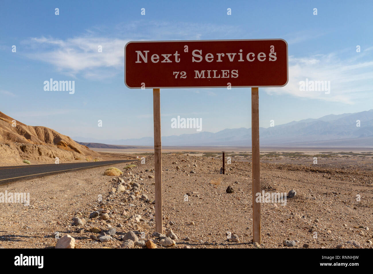 Une 'nouvelle' Services 72 miles signe au début de la route menant de Furnace Creek à Badwater, Death Valley National Park, California, USA. Banque D'Images