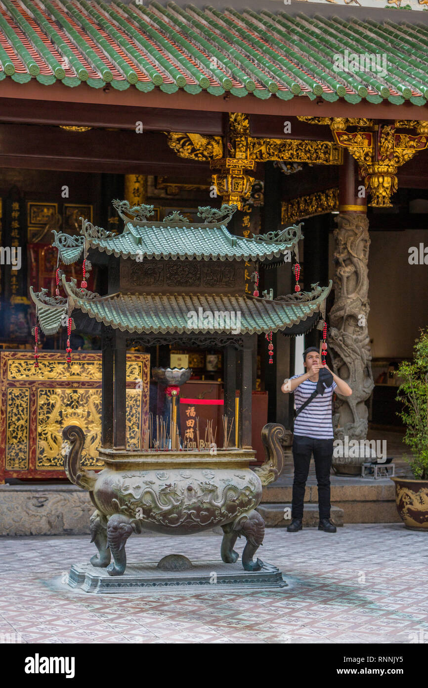 Visiteur avec l'encens dans la cour de Thian Hock Keng Temple taoïste, Singapour. Banque D'Images