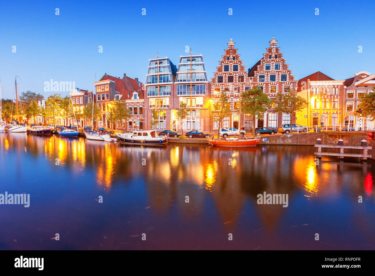 Maisons en bord de mer et rivière Spaarne Haarlem en Hollande au crépuscule. Banque D'Images